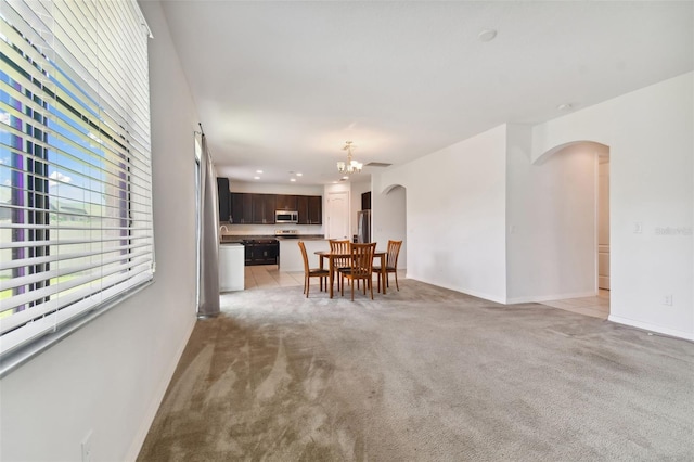 carpeted dining room featuring an inviting chandelier