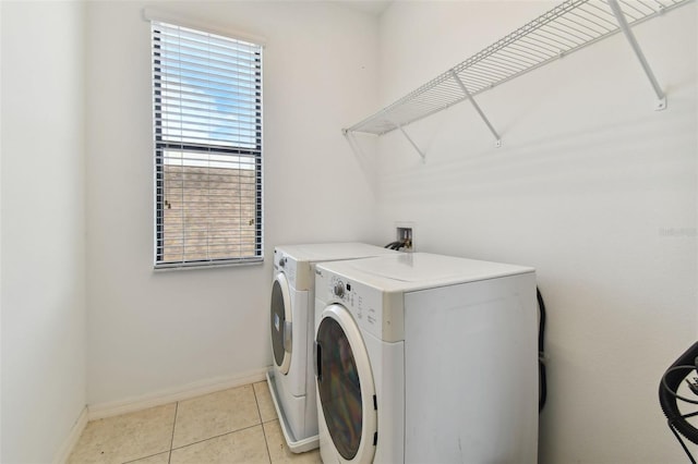 laundry area with light tile patterned floors and washer and dryer