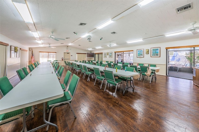 dining room featuring dark hardwood / wood-style flooring, vaulted ceiling, and ceiling fan