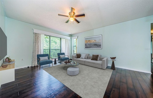 living room featuring wood-type flooring, ceiling fan, and a textured ceiling