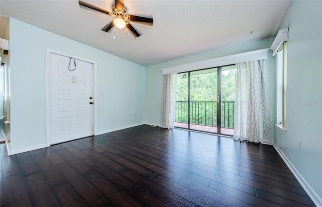 empty room featuring ceiling fan, a textured ceiling, and dark hardwood / wood-style flooring