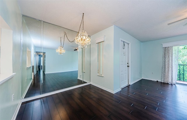 interior space featuring dark hardwood / wood-style floors, a textured ceiling, and a notable chandelier