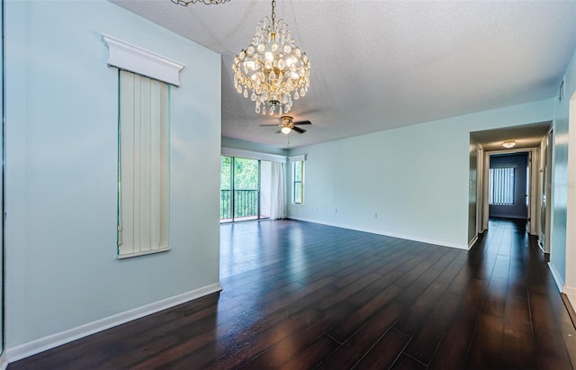 spare room featuring dark hardwood / wood-style floors, ceiling fan with notable chandelier, and a textured ceiling