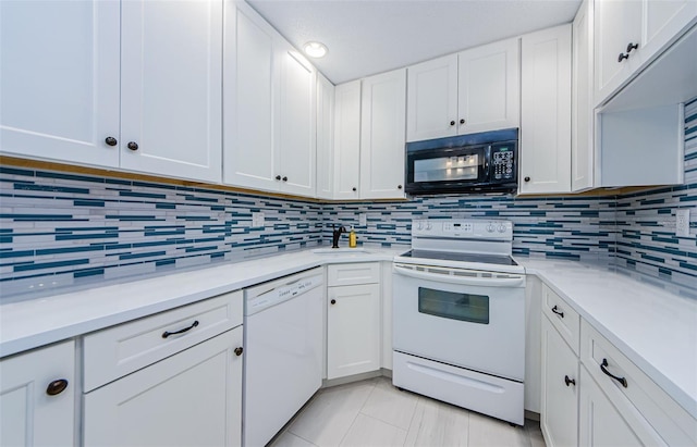 kitchen featuring white cabinetry, white appliances, sink, and backsplash