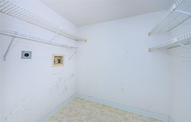 laundry area with electric dryer hookup, hookup for a washing machine, and a textured ceiling