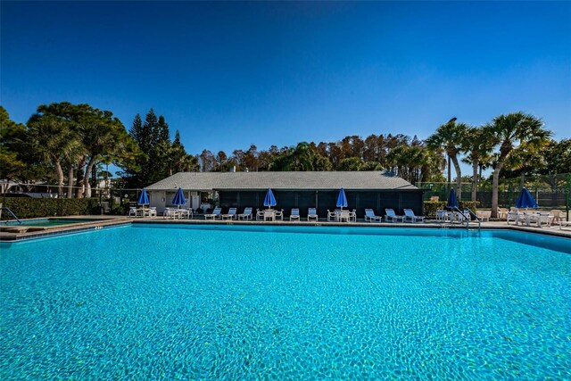 view of swimming pool with a hot tub