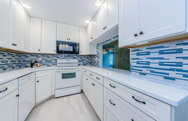 kitchen with white cabinets, decorative backsplash, kitchen peninsula, sink, and white appliances