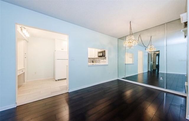 unfurnished dining area featuring hardwood / wood-style floors and a chandelier