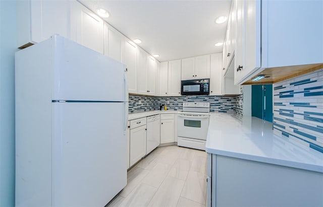 kitchen with white appliances, decorative backsplash, and white cabinets