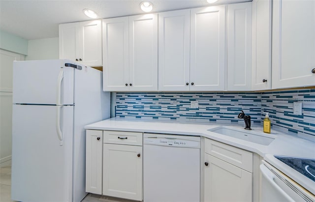 kitchen with sink, backsplash, white cabinets, and white appliances