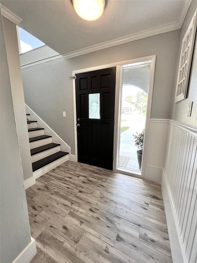 entrance foyer featuring light wood-type flooring and ornamental molding