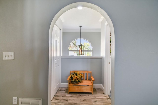 living area featuring crown molding and light wood-type flooring