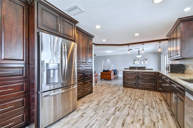 kitchen with stainless steel appliances, light hardwood / wood-style floors, light stone countertops, decorative light fixtures, and dark brown cabinetry