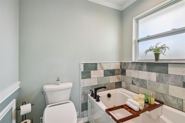 bathroom with ornamental molding, a bathtub, and toilet