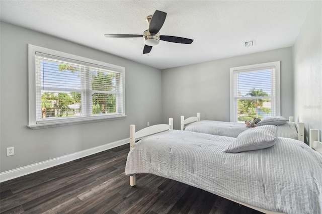 bedroom featuring multiple windows, hardwood / wood-style floors, and ceiling fan