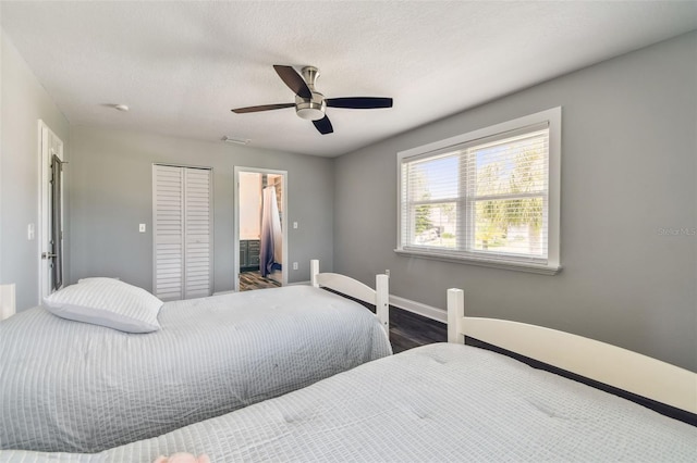 bedroom featuring a closet, hardwood / wood-style flooring, ensuite bathroom, and ceiling fan