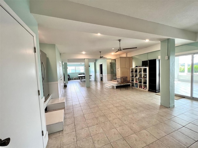 unfurnished living room with light tile patterned floors and ceiling fan