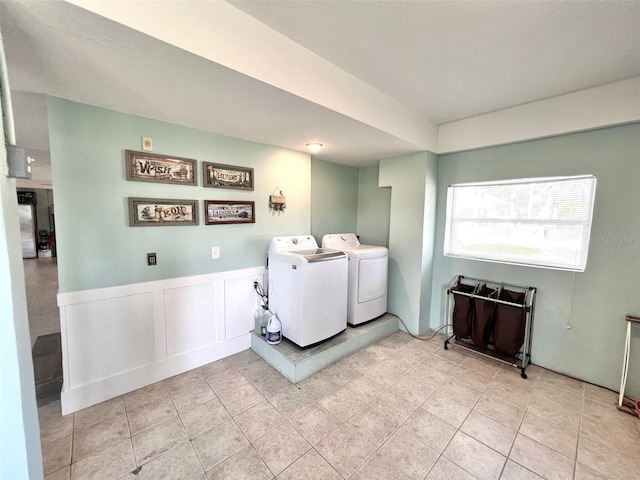 clothes washing area with light tile patterned floors and independent washer and dryer