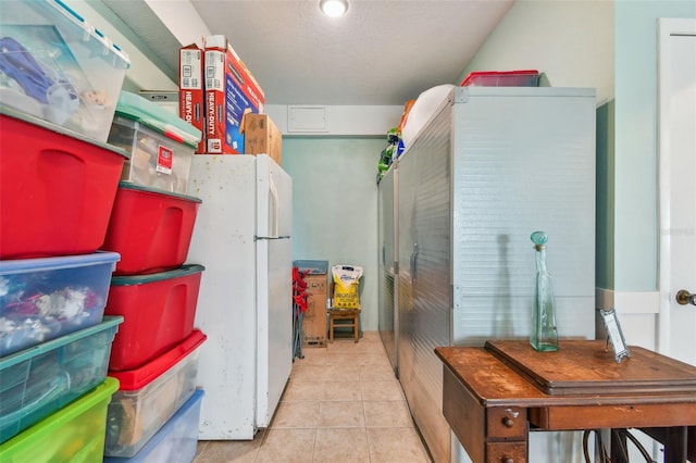 interior space with white fridge and light tile patterned floors