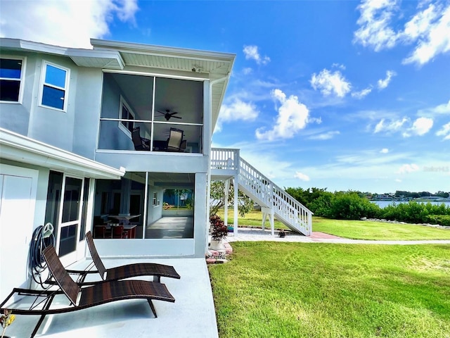 rear view of property featuring a patio, a lawn, and ceiling fan