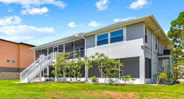 rear view of property with a yard and a sunroom