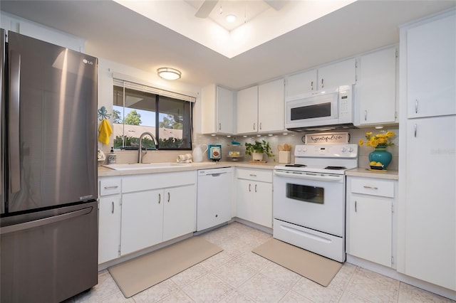 kitchen featuring white appliances, sink, and white cabinets