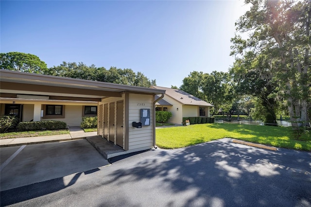 view of home's exterior with a carport and a lawn