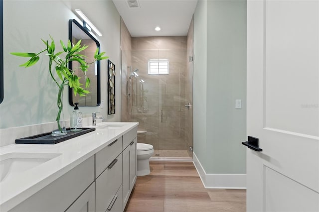 bathroom featuring hardwood / wood-style floors, toilet, an enclosed shower, and vanity