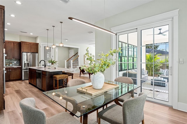 dining room featuring sink and light hardwood / wood-style flooring