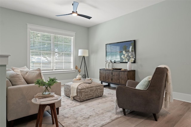 living area with hardwood / wood-style floors and ceiling fan