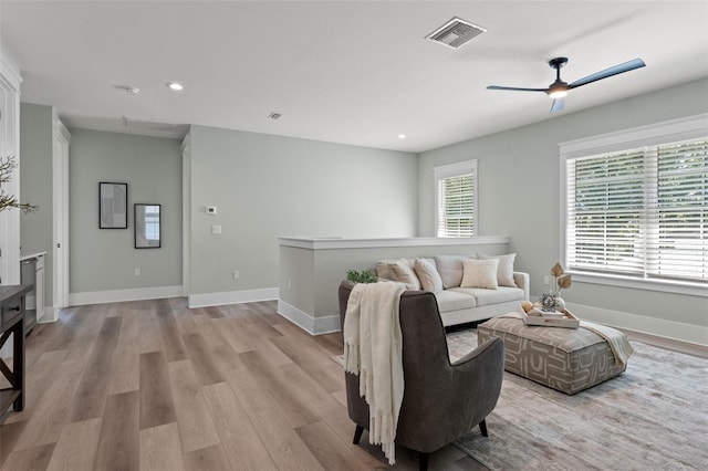 living room with light wood-type flooring and ceiling fan