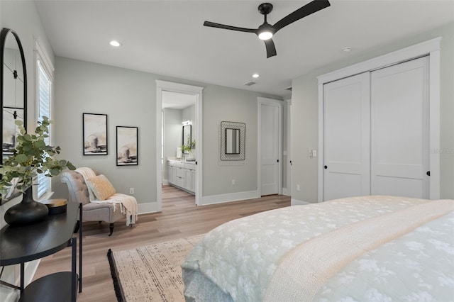 bedroom featuring light hardwood / wood-style floors, a closet, ensuite bath, and ceiling fan