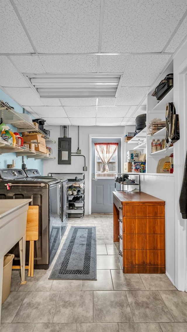 kitchen with light tile patterned flooring, washer and clothes dryer, electric panel, and a paneled ceiling