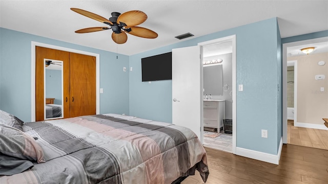 bedroom featuring hardwood / wood-style floors, a closet, ceiling fan, and ensuite bathroom