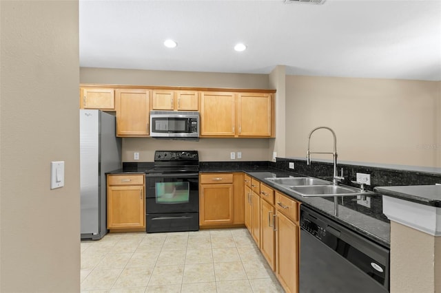 kitchen with light tile patterned flooring, dark stone counters, sink, and black appliances