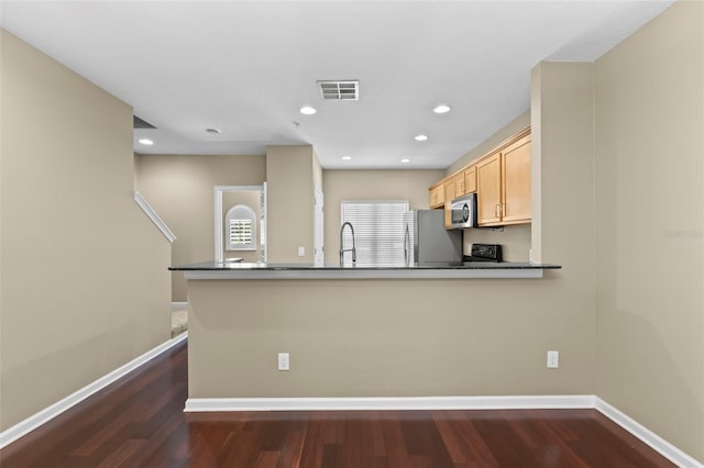 kitchen with dark wood-type flooring, sink, light brown cabinets, appliances with stainless steel finishes, and kitchen peninsula