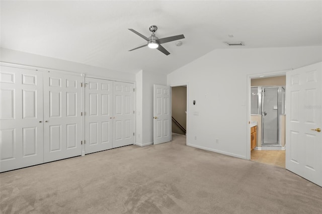 unfurnished bedroom with light colored carpet, ceiling fan, vaulted ceiling, and ensuite bath