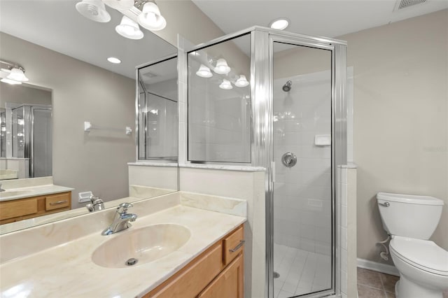 bathroom featuring vanity, tile patterned flooring, toilet, and walk in shower