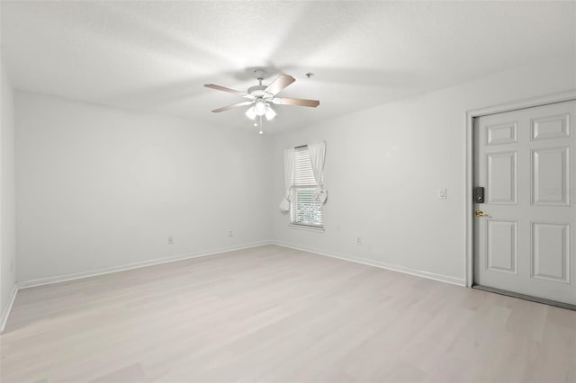 empty room featuring ceiling fan, a textured ceiling, and light wood-type flooring