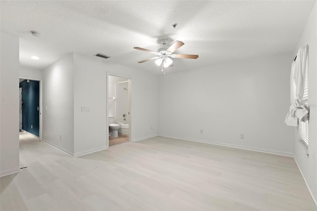 unfurnished bedroom featuring ensuite bathroom, light wood-type flooring, and ceiling fan