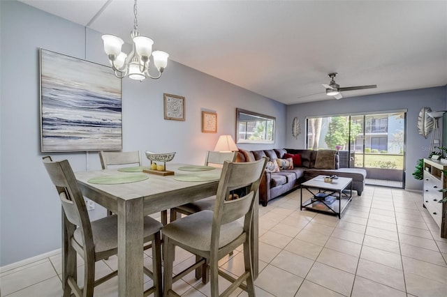 tiled dining room with ceiling fan with notable chandelier