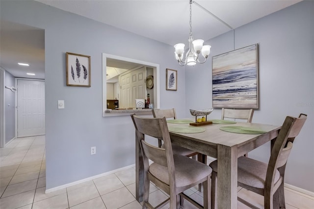 dining area with light tile patterned floors and a chandelier