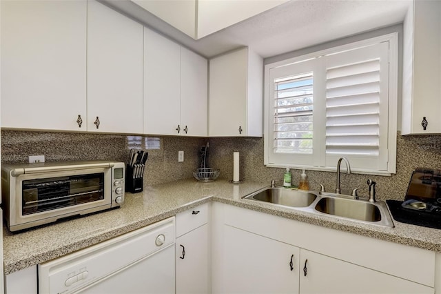 kitchen with sink, white cabinets, white dishwasher, and decorative backsplash