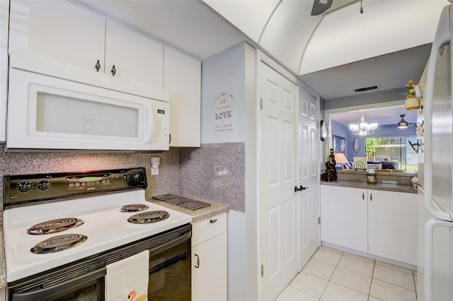 kitchen with range with electric stovetop, white cabinets, a chandelier, backsplash, and light tile patterned floors