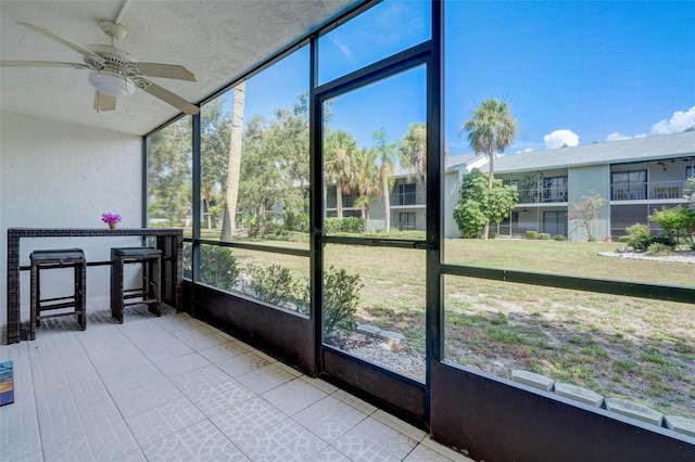 sunroom featuring ceiling fan