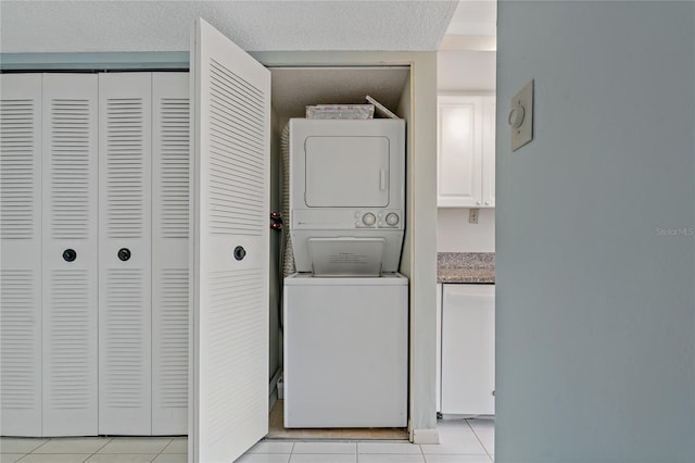 laundry area with light tile patterned flooring and stacked washer and clothes dryer