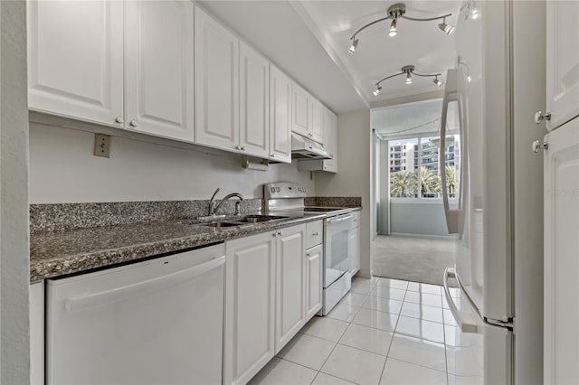 kitchen featuring white appliances, dark stone countertops, sink, and white cabinets