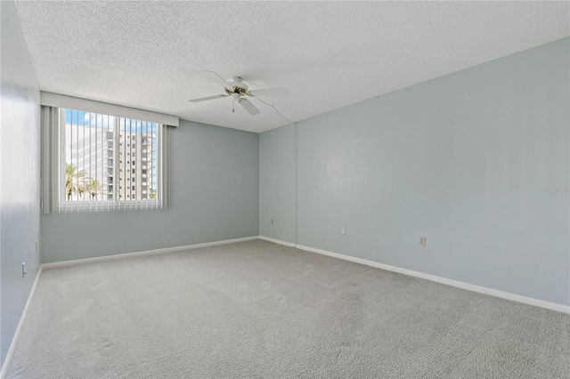 spare room with carpet flooring, a textured ceiling, and ceiling fan