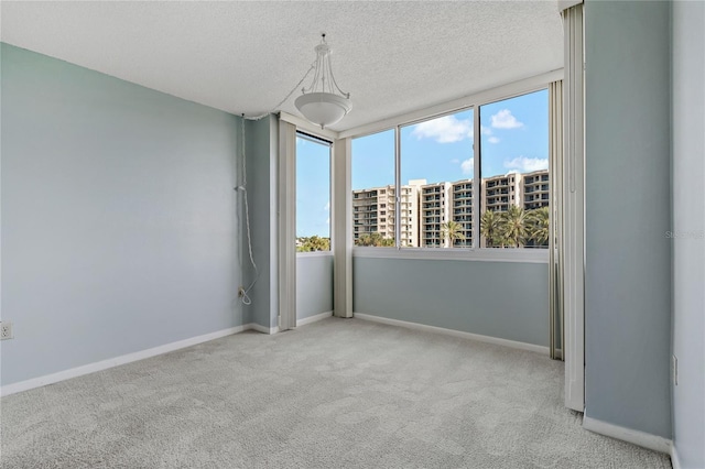 carpeted spare room with a textured ceiling