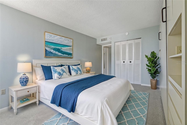 bedroom featuring carpet flooring, a textured ceiling, and a closet